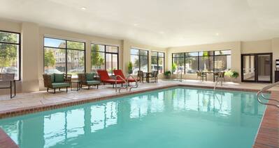 Bright indoor pool featuring ample seating, hot tub, and large windows.
