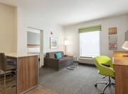 Spacious accessible suite featuring living area with breakfast bar, work desk, TV, and sofa.