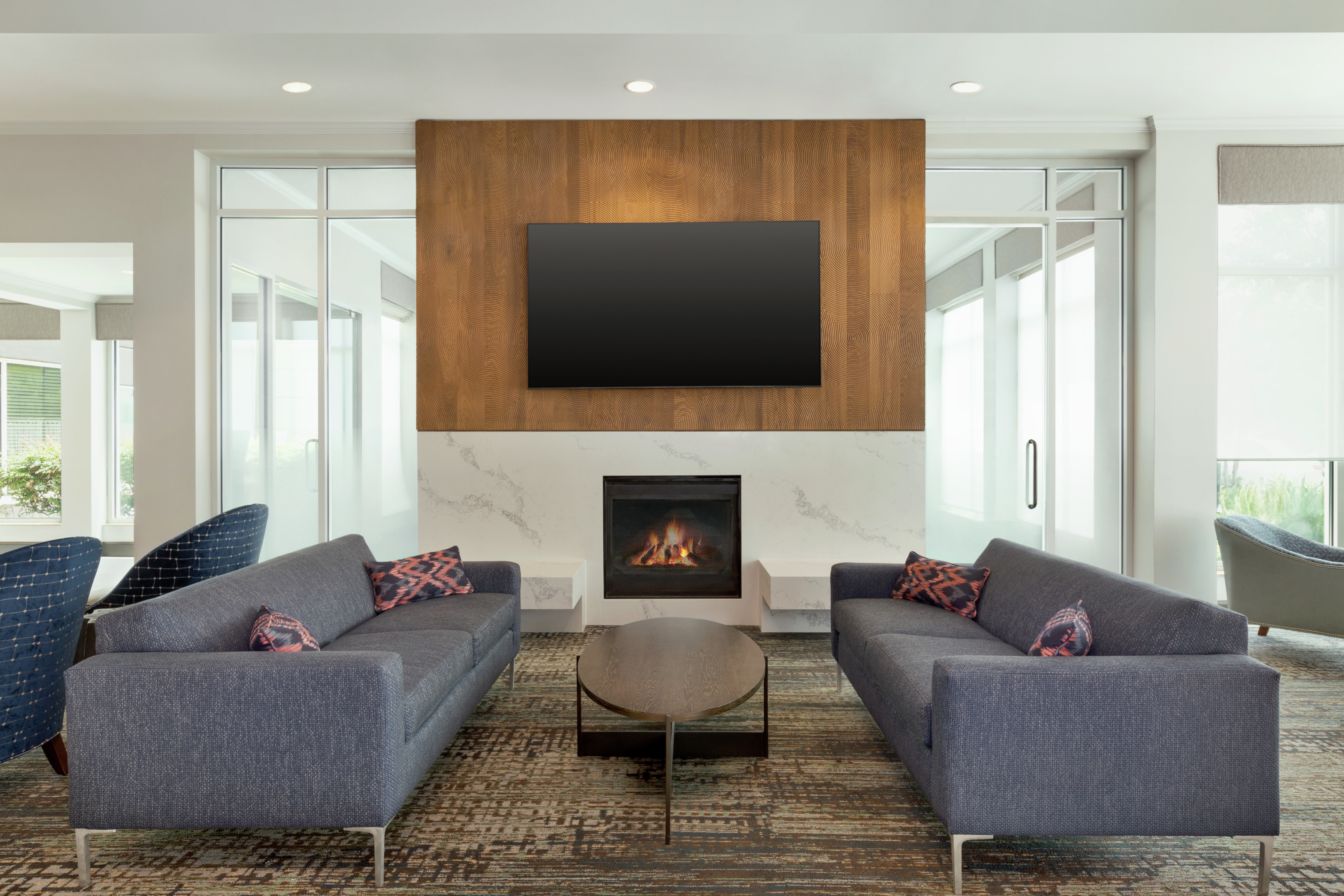 Comfortable lounge area in lobby featuring ample seating, fireplace, and TV.