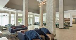 Spacious hotel lobby featuring high ceilings, ample seating, and dining area.