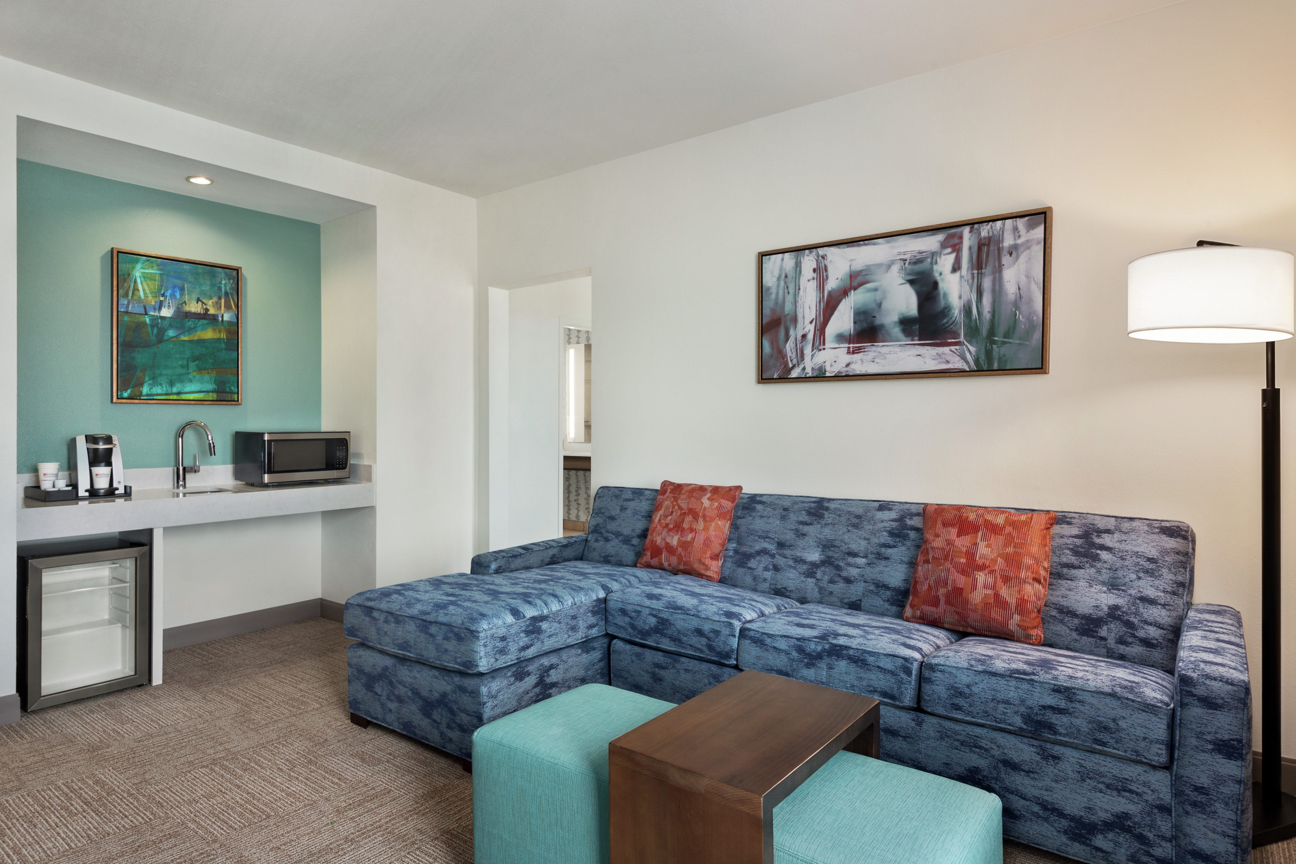 Spacious living area in executive king guest room featuring comfortable sofa and convenient wet bar.