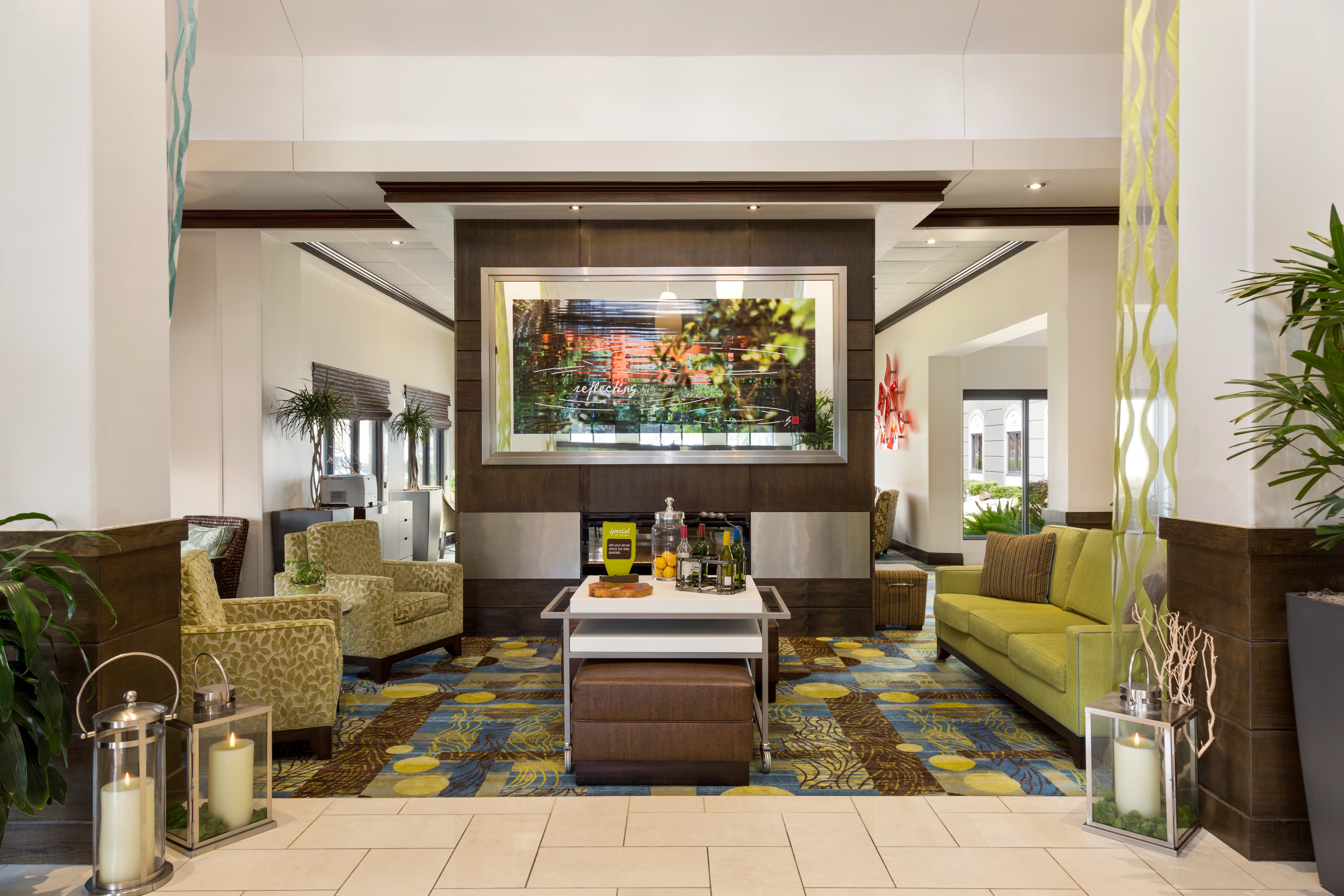 Lobby Hospitality Lounge Area By Fireplace With Art Feature, Soft Seating, and Beverage Station