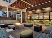 Beautiful outdoor lounge area with comfortable sofa style seating, firepit, and string lights.