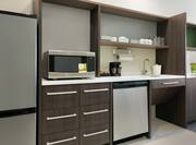 Fully equipped accessible kitchen featuring fridge, dishwasher, microwave, and coffee maker.
