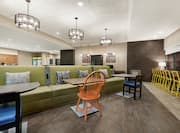 Spacious lobby area for guests to relax featuring stylish banquette seating, front desk, and business center.