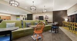 Spacious lobby area for guests to relax featuring stylish banquette seating, front desk, and business center.