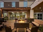 Outdoor Patio Area with Firepit, Armchairs and Sofa at Night