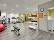 Fitness Center with Weight Bench, Treadmills, Cycle Machine and Cross-trainer with View of Guest Laundry Room