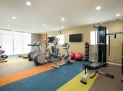 Spin2Cycle Fitness Area with Outside View, TV, Free Weights, Cardio Equipment, Red Exercise Balls, and Weight Bench