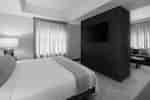 Bed in room with TV and curtains