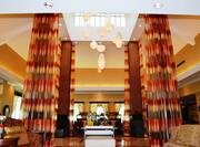 Beverage Service Table, Long Drapes, Decorative Lighting, and Mixed Lounge Seating in Vast Lobby