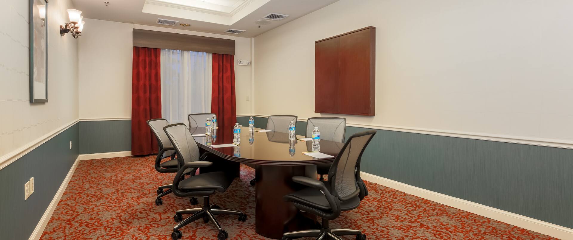 Nanuet Boardroom With Seating for Six Around Oval Table, Window, WallArt, and Media Cabinet