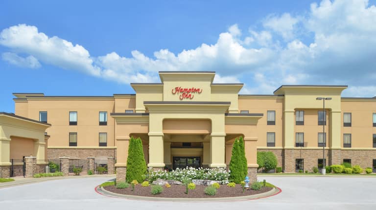 Daytime View of Hotel Exterior With Signage, Entrance, and Landscaping