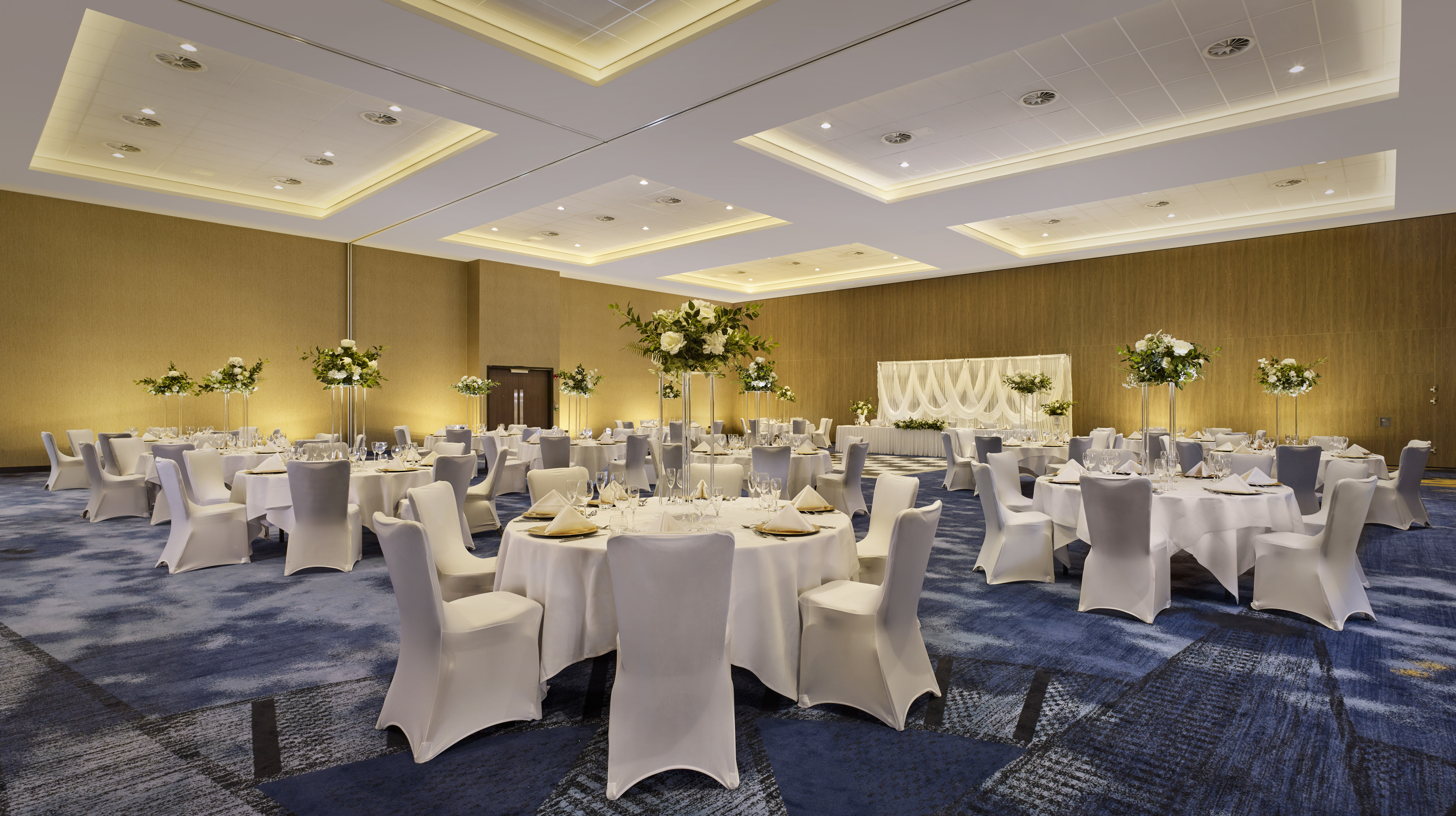 wedding reception setup with round tables in ballroom