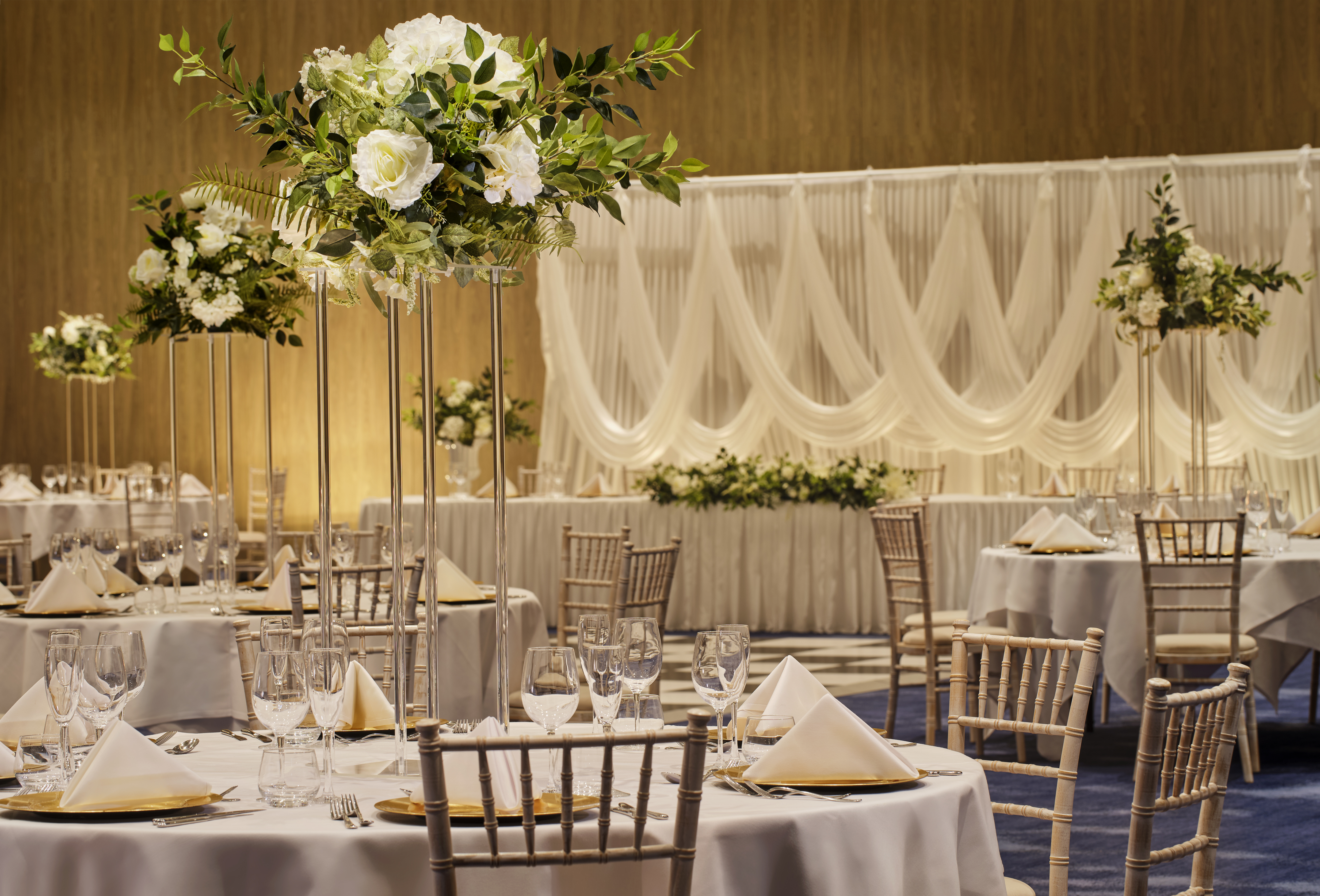wedding reception setup in ballroom with round tables