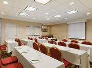 Meeting Room in Classroom Setting With Tables and Chairs Facing Presentation Screen