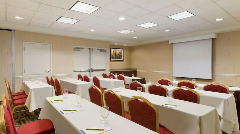 Meeting Room in Classroom Setting With Tables and Chairs Facing Presentation Screen