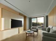 King deluxe suite living room with sofa and wall mounted TV and balcony