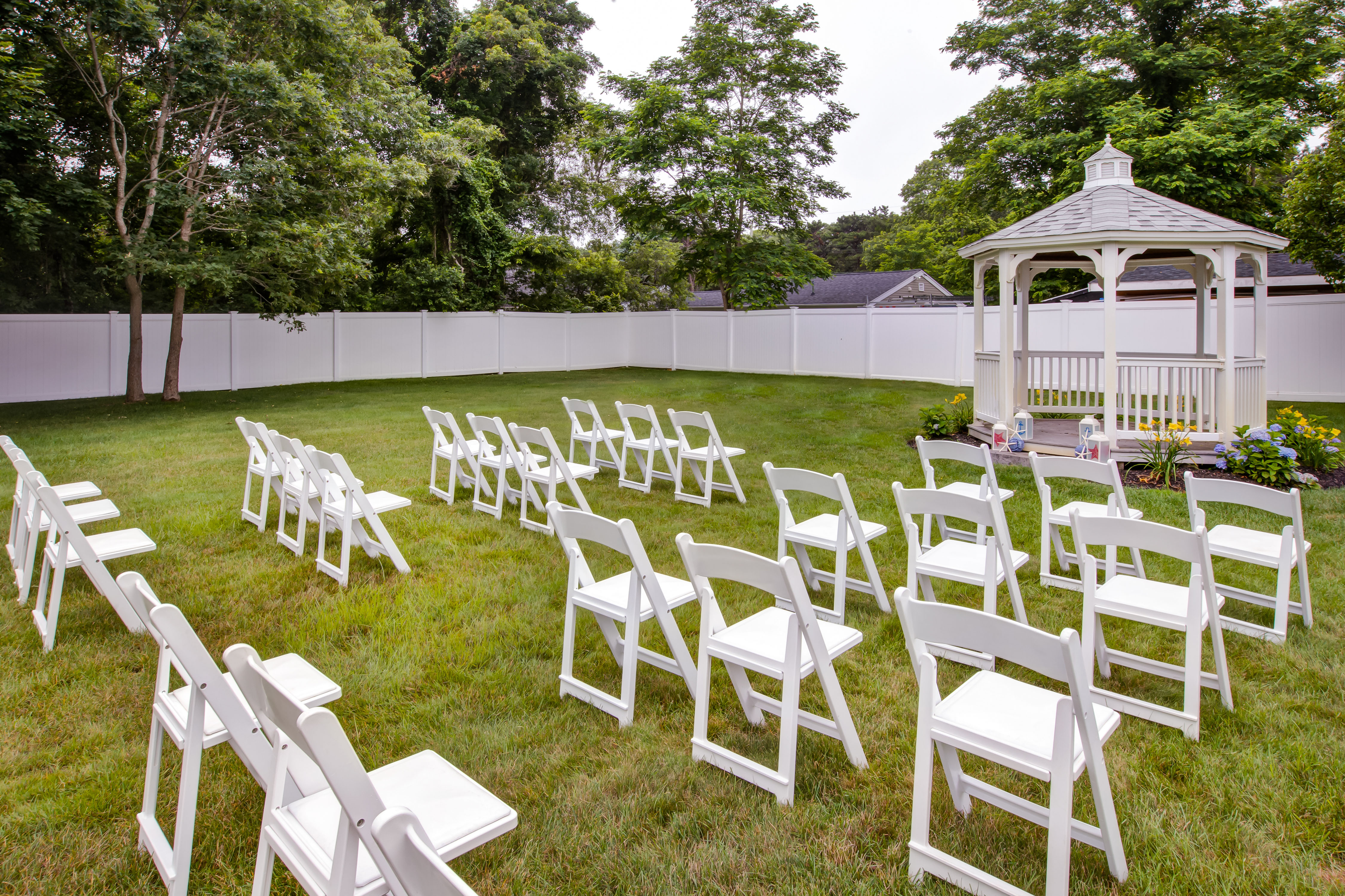 White Chairs Set Up for Reception on Hotel Lawn with Gazebo