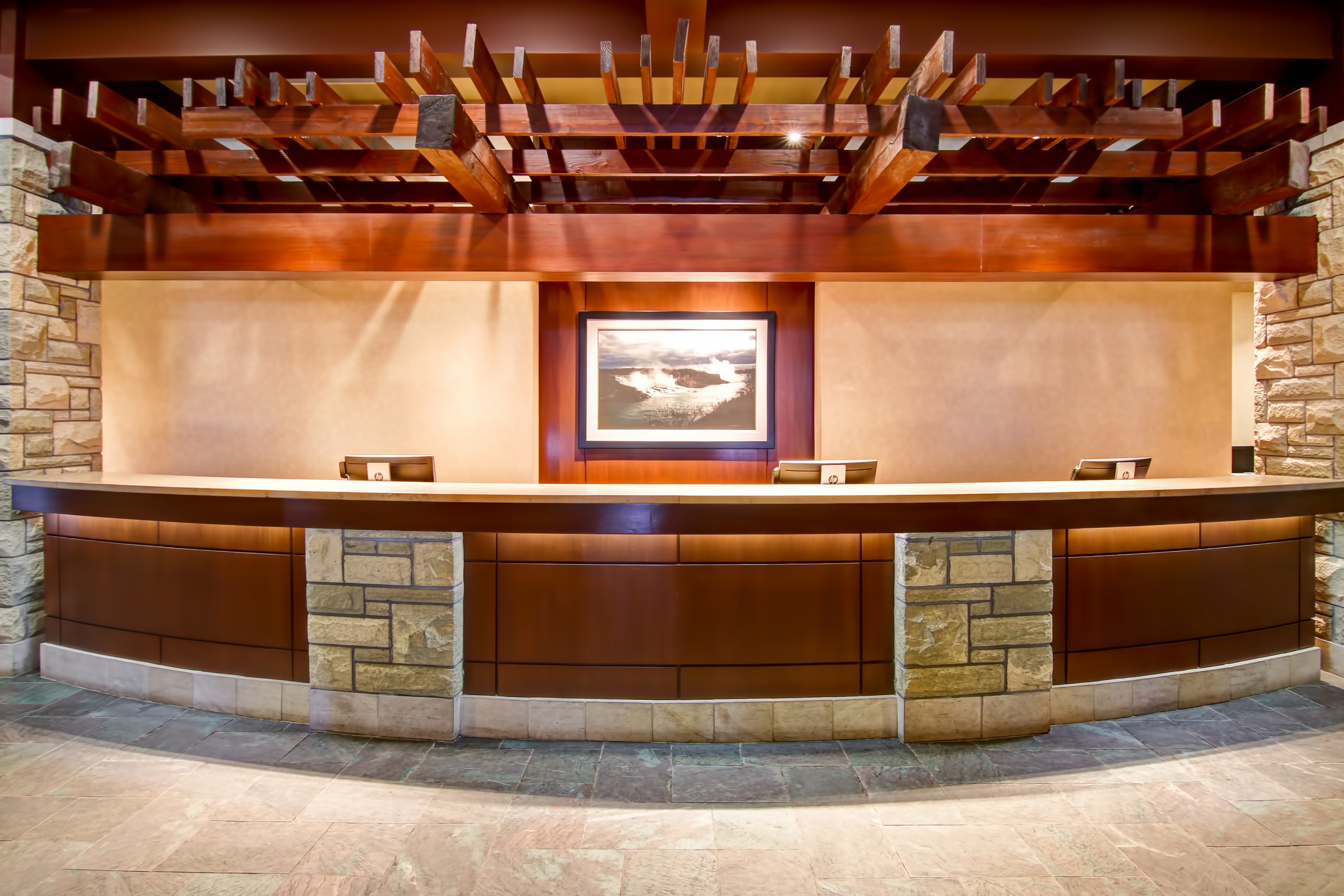 Hotel front desk with art displayed on the wall behind counter