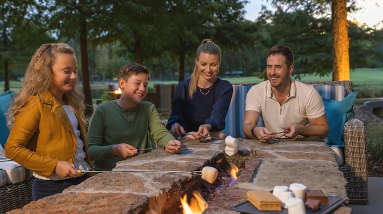 A family enjoying a cozy evening by the fire pit making s'mores