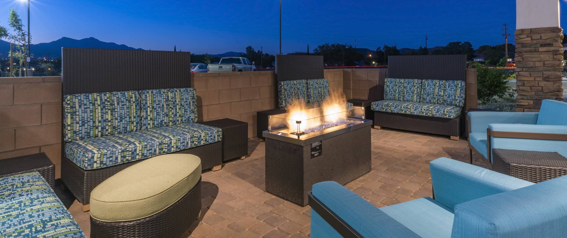 Outdoor Patio Area with Soft Chairs, Footrest and Soft Armchairs at Night