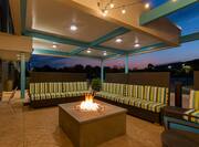 Illuminated Outdoor Lounge With Soft Seating Around Fire Pit at Night