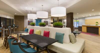 Tables, Chairs and Soft Seating in Lobby With View of Front Desk and Snack Shop