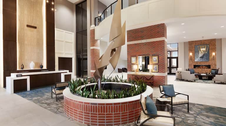 Front Desk Reception Area with Armchairs and Statue