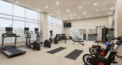 Convenient on-site fitness center featuring ample space, cardio machines, and free weights.