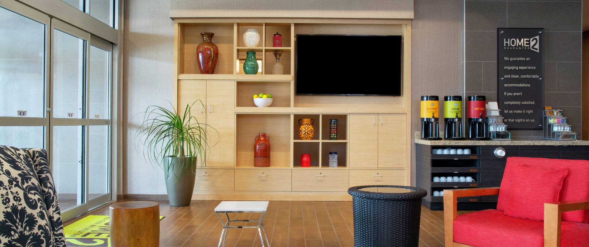 A Lobby Seating Area next to a Cabinet with TV and Coffee Service