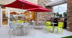 An Outdoor Patio with Umbrella Tables and BBQ Grills