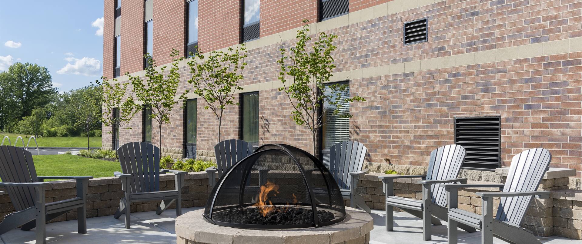 Chairs Around Fire Pit on Outdoor Patio by Hotel Exterior
