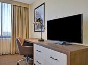 guest room with television work desk and window