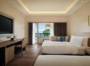 Twin beds room with sea view and wall mounted TV