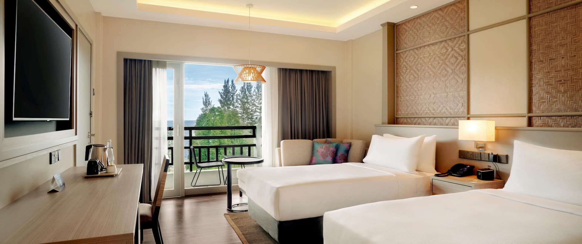 Twin beds guest room with chair, wall mounted TV and sea view