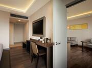 King one bedroom suite and living room with wall mounted TV and desk