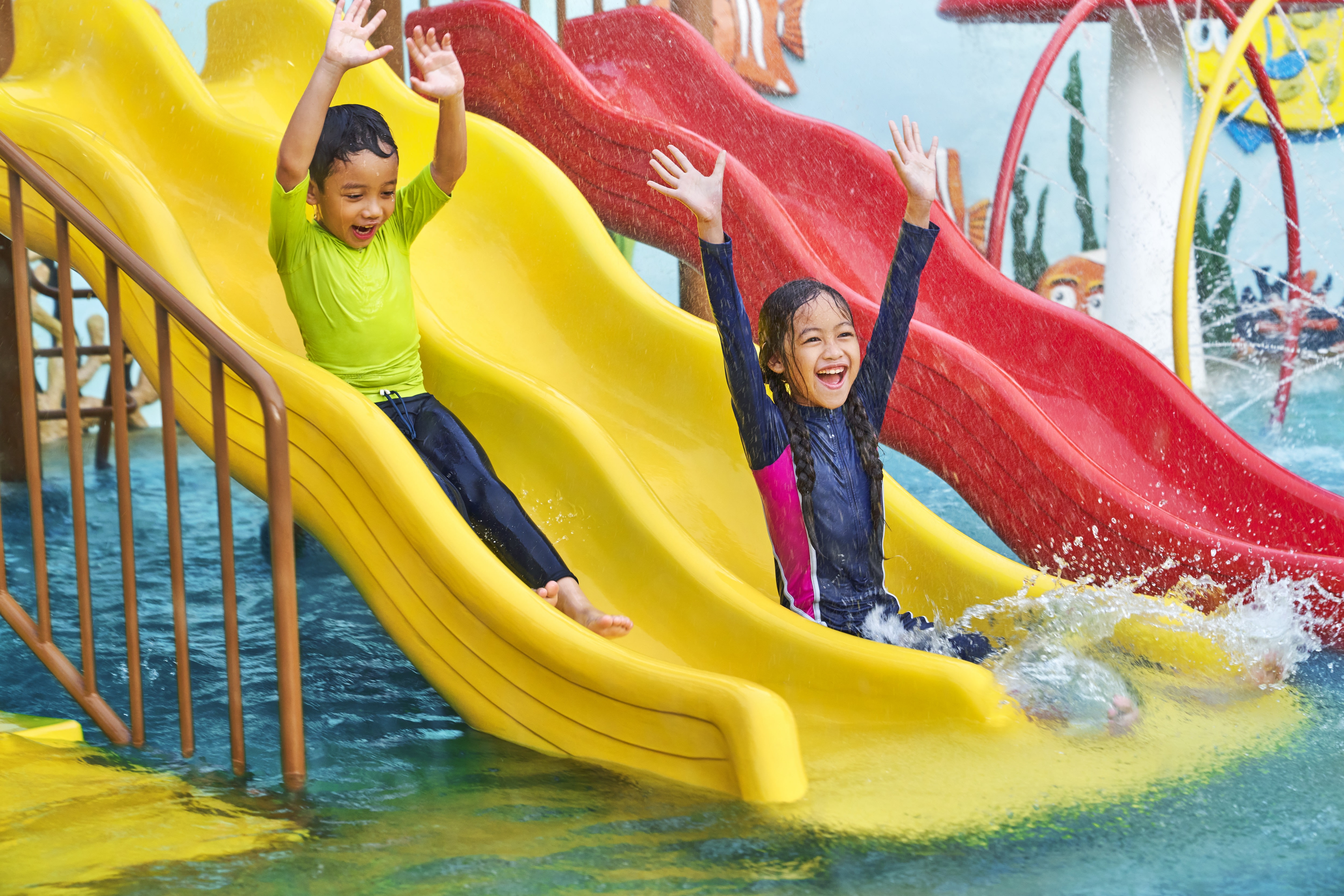 Kids splash pool with two children going down slide
