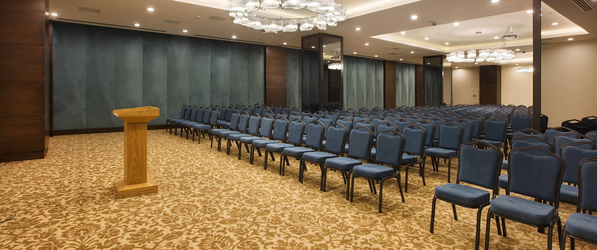 Rosa Conference Room Arranged Theater Style With Rows of Blue Chairs Facing Podium