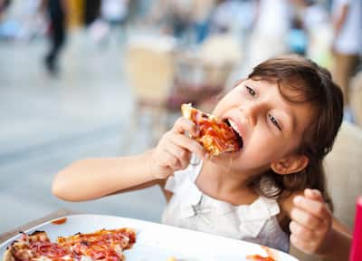 Little Girl Eating Pizza On Sidewalk