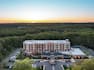 Aerial image captured hotel with lush greenery and beautiful sunset.