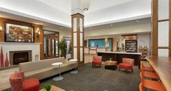 Spacious hotel lobby featuring ample seating, fireplace, and convenient snack shop.