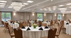 Spacious combined meeting rooms fully equipped with banquet setup, beautiful floral center pieces, and large windows.