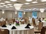 Spacious combined meeting spaces featuring banquet setup with beautiful floral center pieces.