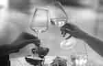 Two hands holding wine glasses