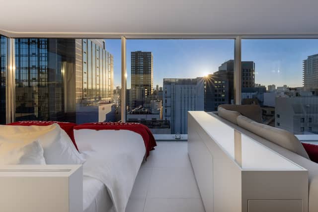 Guestroom bed and city view from window