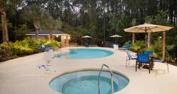 Outdoor Pool and Hot Tub with tables, umbrellas and chaise lounge seating