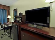 TV, Hospitality Center With Microwave and Mini-Fridge, Work Desk With Illuminated Lamp in Corner by Window With Long Drapes