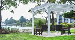 a pergola with chairs facing the water