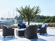 a lounge seating area next to the water and a boat